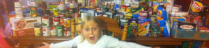 Excited child in front of canned and boxed food items