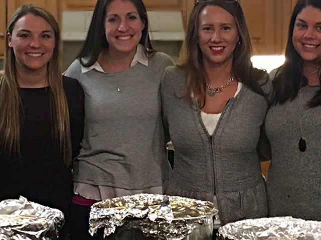 Four female guest chefs standing in front of cooked meals